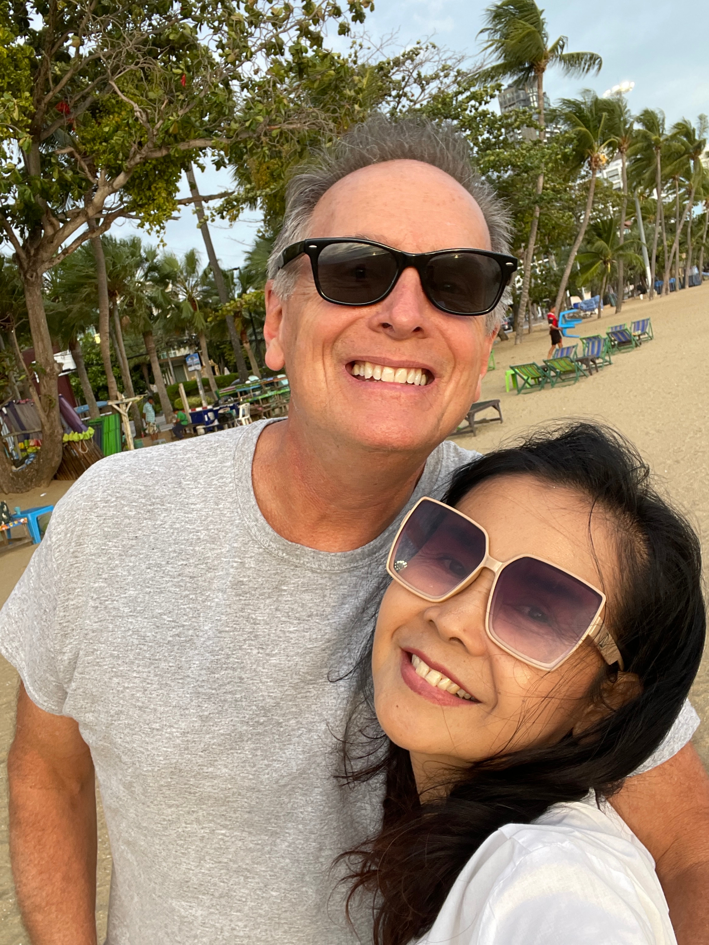 Ethan and Pranisa smiling on the beach in Thailand